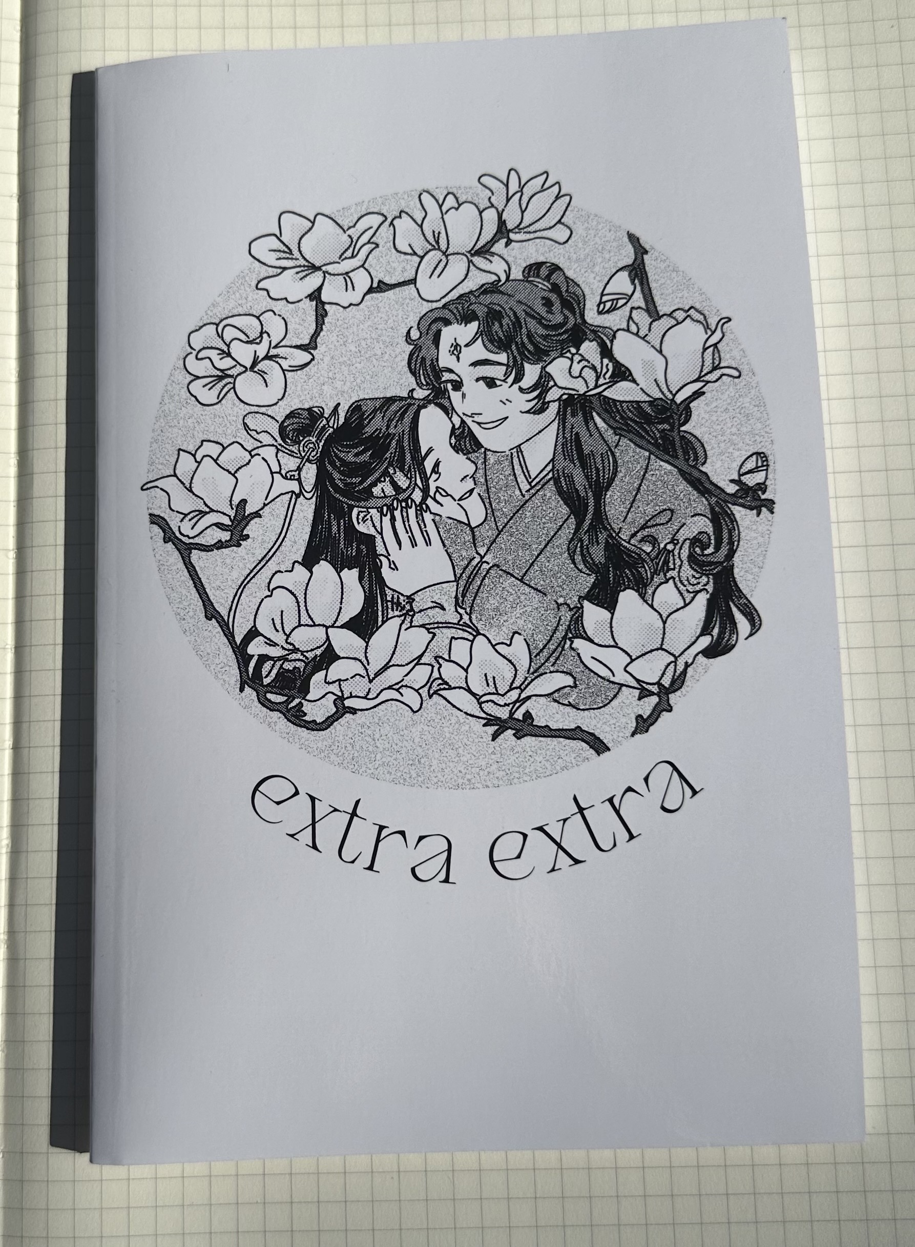 a black and white zine cover of binghe and shen qingqiu embracing. they are surrounded by flowers and the title in a circle.